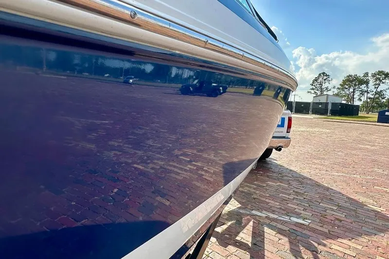 Slide: The Image of 2012 Regal 2100 boat reflecting on a sunny day, parked on a brick surface. - 15