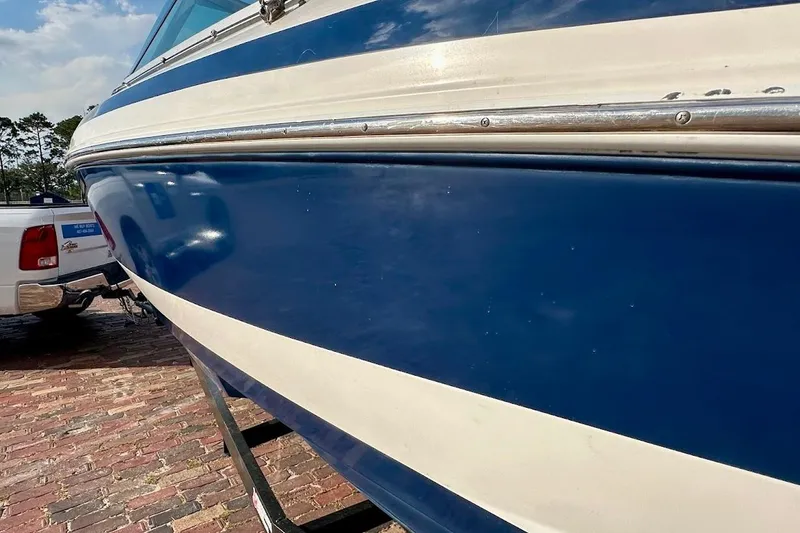 Slide: The Image of 2012 Regal 2100 boat with blue and white hull on a trailer. - 16