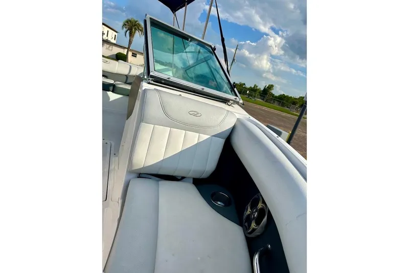 Slide: The Image of 2012 Regal 2100 boat interior with white seating and cup holder, under a blue sky. - 26