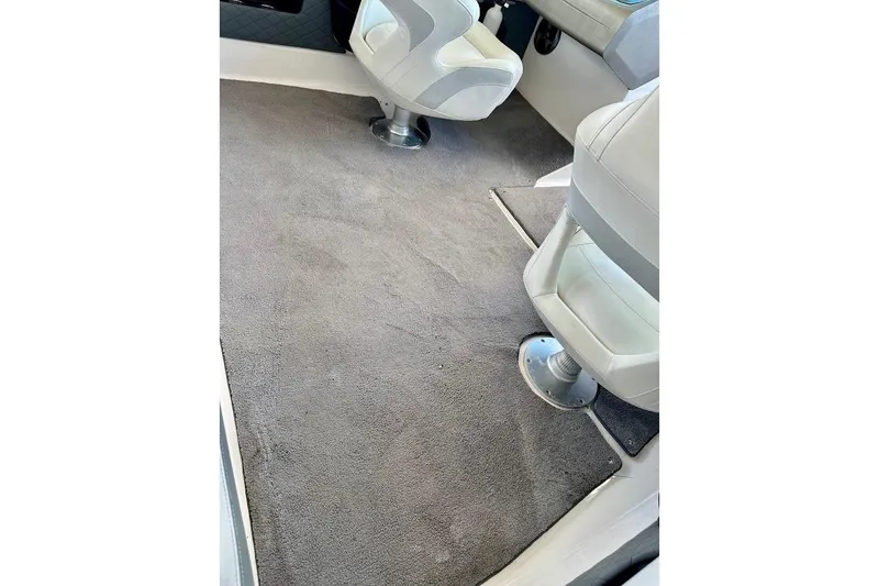 Slide: The Image of Interior of a 2012 Regal 2100 boat with carpeted flooring and swivel seats. - 33