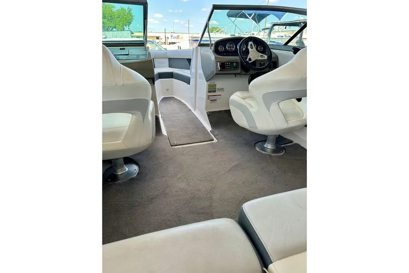 Slide: The Image of Interior of a 2012 Regal 2100 boat with white seating and steering console. - 35