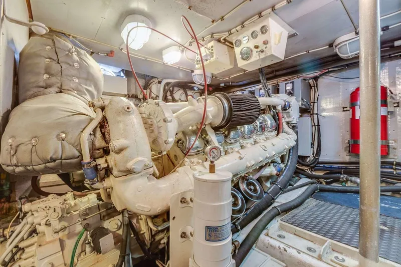 Slide: The Image of Engine room of a 1988 Azimut Motor Yacht, showcasing mechanical components and control panels. - 16