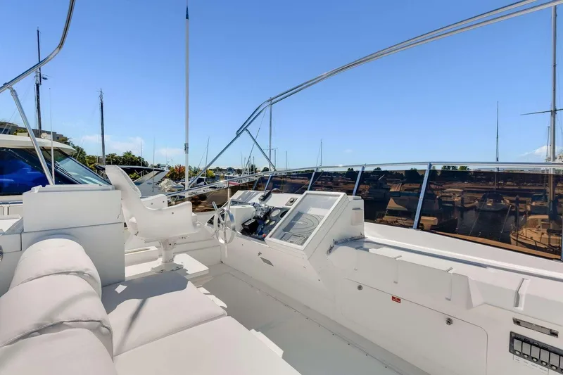 Slide: The Image of 1988 Azimut Motor Yacht helm with white seating and marina view. - 23