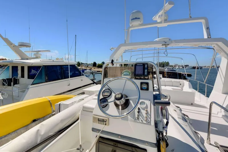 Slide: The Image of 1988 Azimut Motor Yacht helm with navigation equipment, docked in a marina under clear skies. - 27