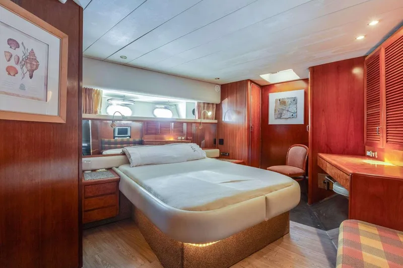 Slide: The Image of Luxurious 1988 Azimut Motor Yacht bedroom with elegant wood finishes and cozy decor. - 30
