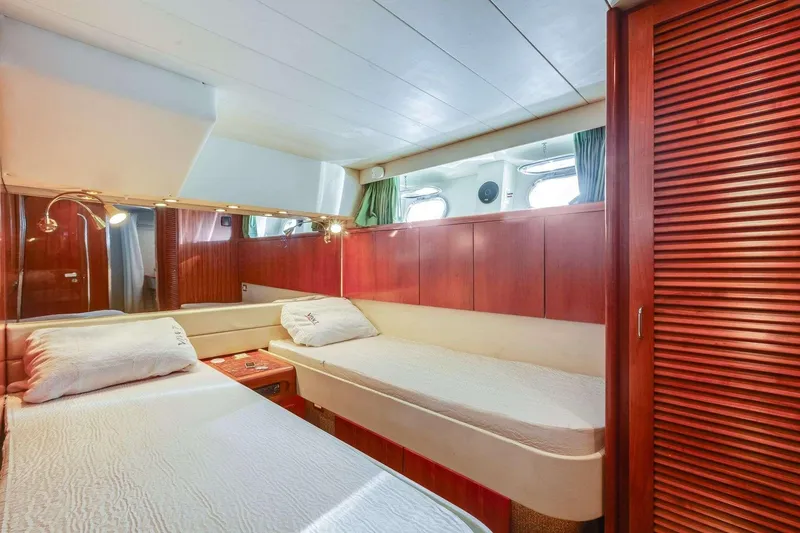 Slide: The Image of Luxurious 1988 Azimut Motor Yacht cabin with twin beds and wooden interior. - 38
