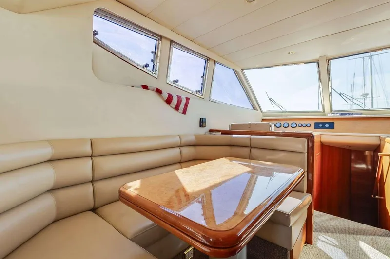 Slide: The Image of Interior of 1988 Azimut Motor Yacht with beige seating and wooden table. - 9
