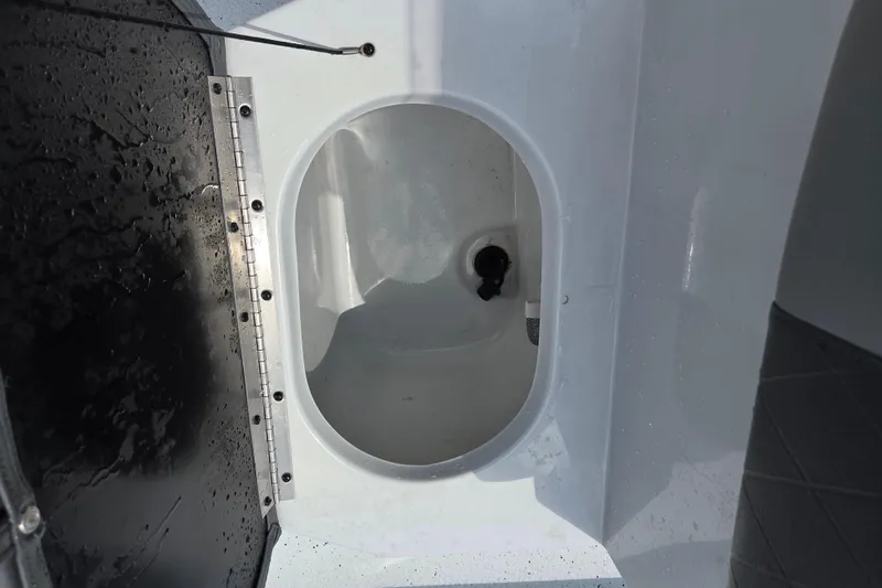 Slide: The Image of 2022 Xpress H22B boat livewell interior with open hatch and drainage system. - 11