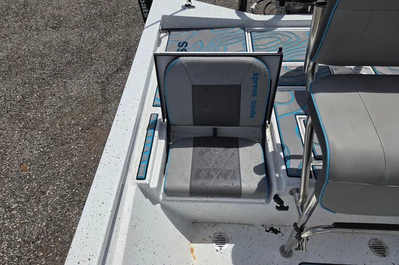Slide: The Image of 2022 Xpress H22B boat interior with gray seating and blue accents. - 13