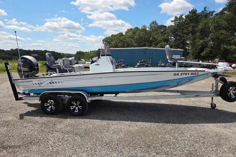 Slide: The Image of 2022 Xpress H22B boat on trailer, parked outdoors under a blue sky. - 4