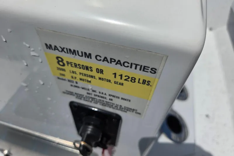Slide: The Image of 2022 Xpress H22B boat capacity label, max 8 persons or 1128 lbs. - 9