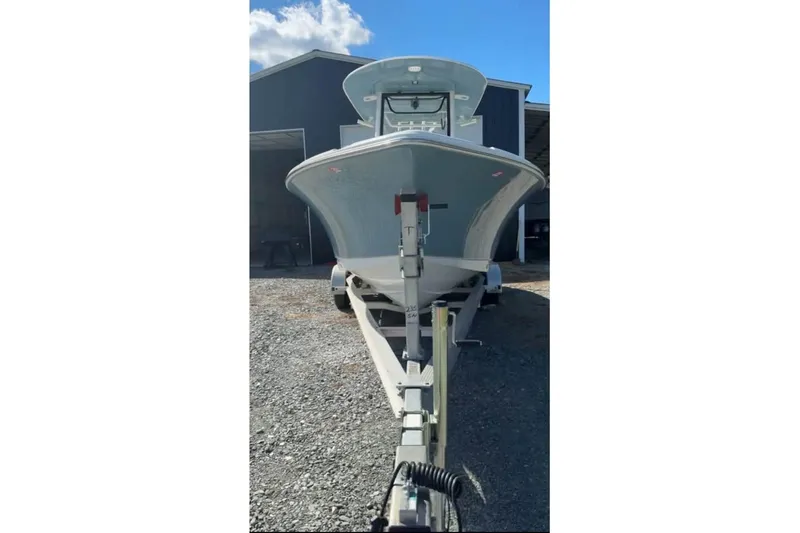 Slide: The Image of 2026 Sea Hunt Ultra 235 SE boat on trailer, parked outdoors under clear sky. - 11