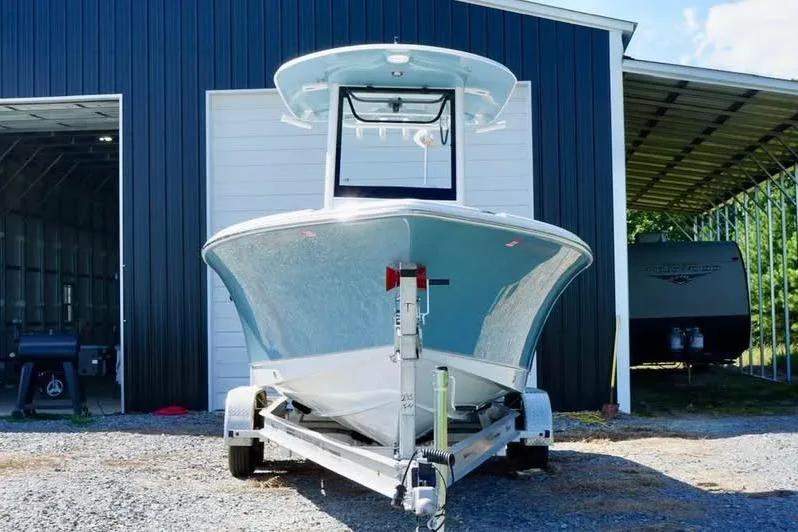 Slide: The Image of 2026 Sea Hunt Ultra 235 SE boat on trailer outside a garage. - 2