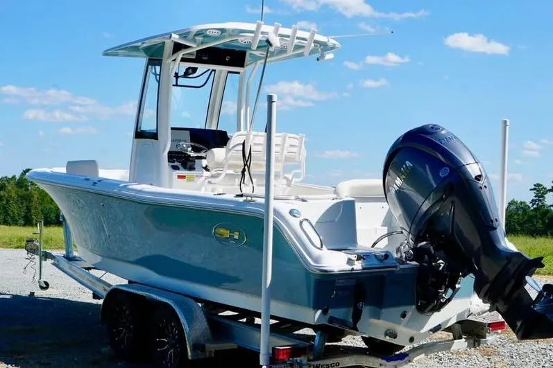 Slide: The Image of 2026 Sea Hunt Ultra 235 SE boat on trailer, featuring sleek design and powerful outboard motor. - 4