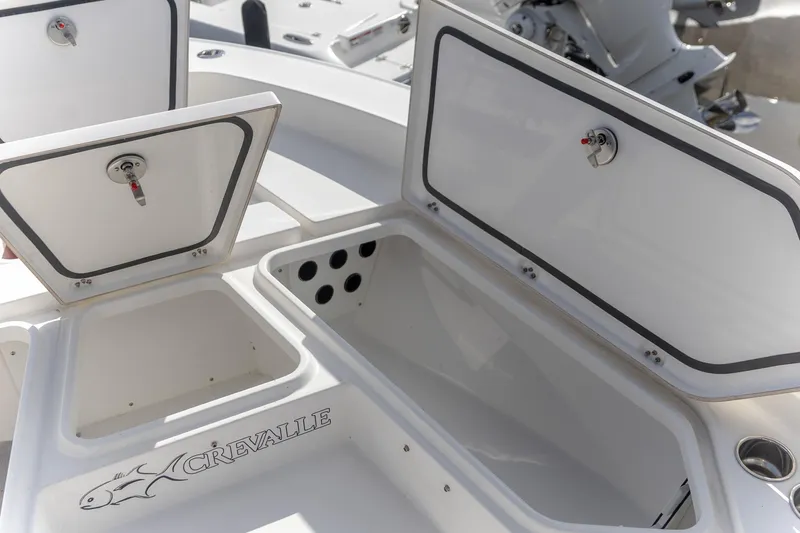 Slide: The Image of 2024 Crevalle 26 HCO boat storage compartments with open lids, showcasing interior space. - 12