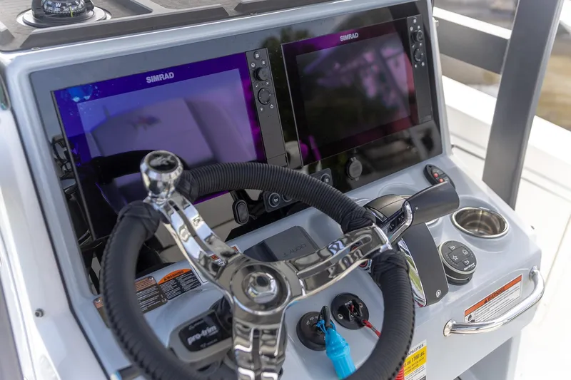 Slide: The Image of 2024 Crevalle 26 HCO boat dashboard with dual Simrad displays and steering wheel. - 18