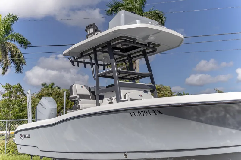 Slide: The Image of 2024 Crevalle 26 HCO boat with T-top, parked outdoors under a blue sky. - 2
