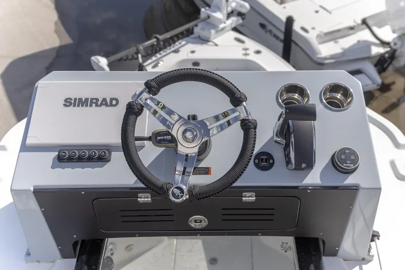 Slide: The Image of 2024 Crevalle 26 HCO boat dashboard with Simrad electronics and steering wheel. - 4