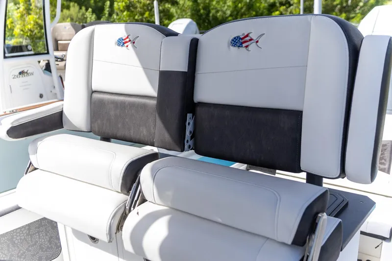 Slide: The Image of 2024 Crevalle 26 HCO boat seating with American flag fish emblem, outdoor setting. - 6