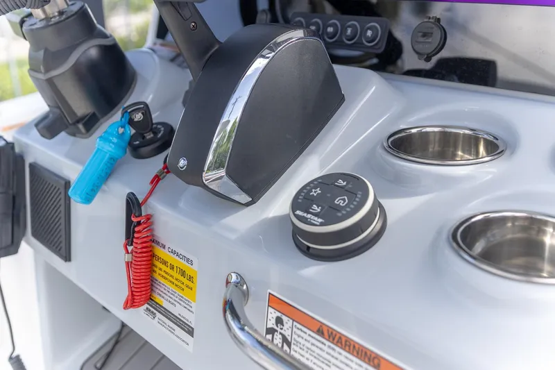 Slide: The Image of 2024 Crevalle 26 HCO boat console with controls and cup holders. - 8