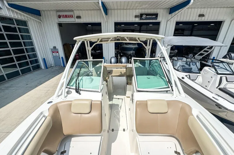 Slide: The Image of 2018 Sailfish 275 DC boat interior at dealership, featuring comfortable seating and windshield. - 11