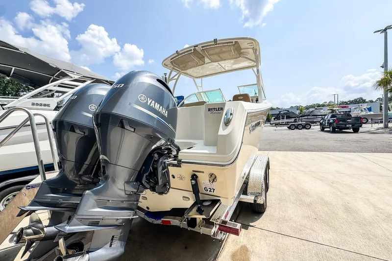 Slide: The Image of 2018 Sailfish 275 DC boat with dual Yamaha engines, parked outdoors under a clear sky. - 3