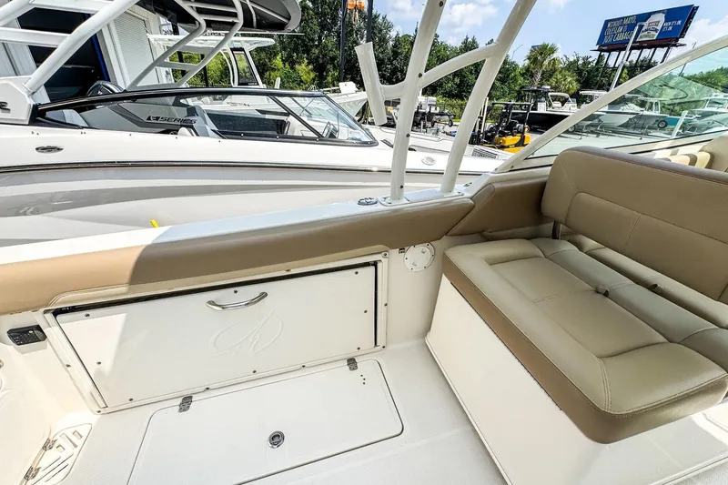 Slide: The Image of 2018 Sailfish 275 DC boat interior with beige seating and storage compartment. - 7