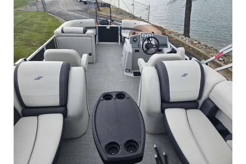 Slide: The Image of 2023 Starcraft EX 22 R pontoon boat interior with plush seating and steering console. - 16