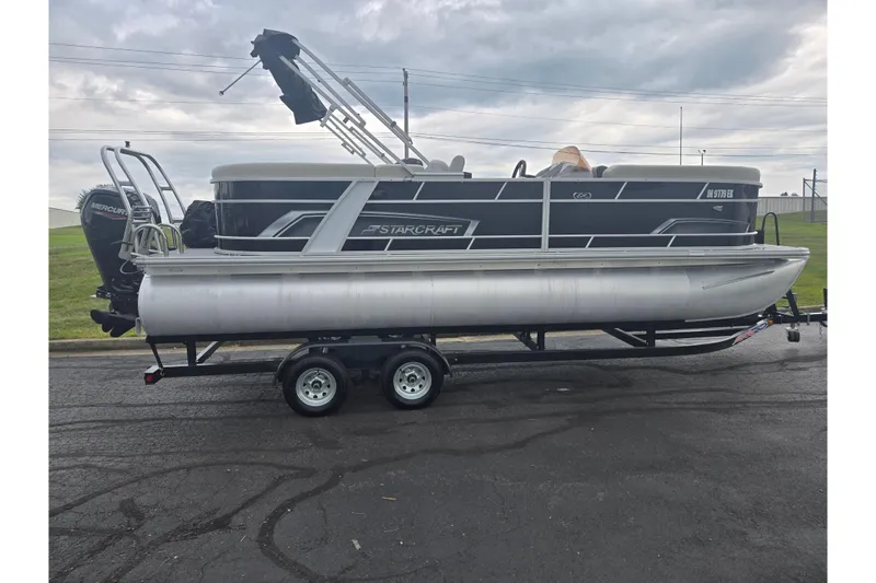 Slide: The Image of 2023 Starcraft EX 22 R pontoon boat on trailer, overcast sky background. - 4