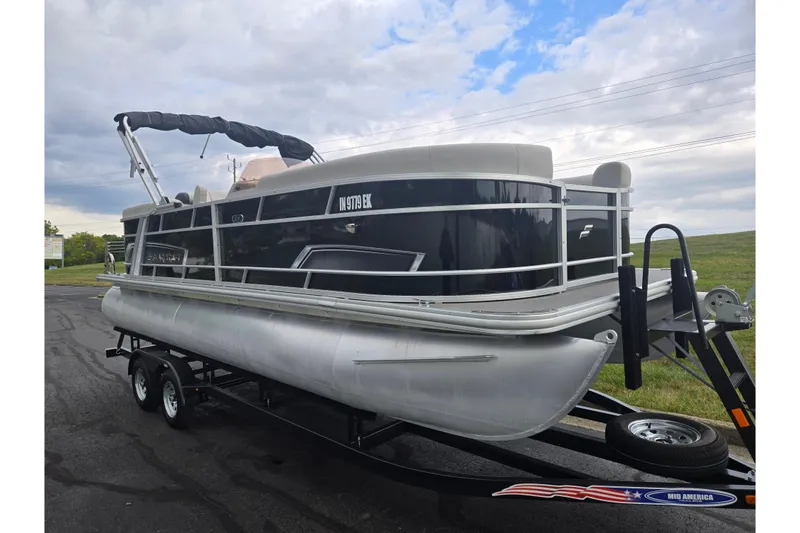 Slide: The Image of 2023 Starcraft EX 22 R pontoon boat on trailer under cloudy sky. - 5