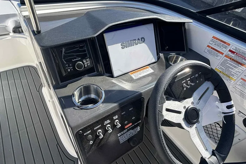 Slide: The Image of 2026 Bayliner VR6 Bowrider I/O dashboard with Simrad display and steering wheel. - 3