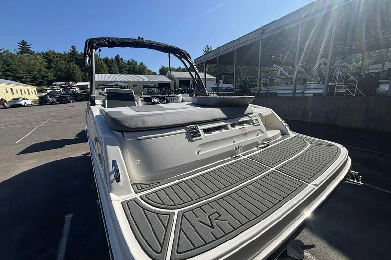 Slide: The Image of 2026 Bayliner VR6 Bowrider I/O boat with spacious deck in a marina setting. - 7