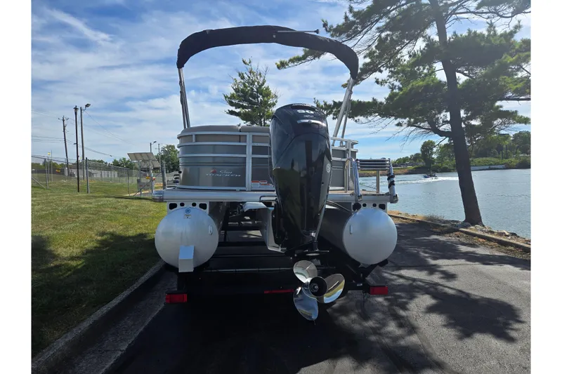Slide: The Image of 2024 Sun Tracker Party Barge 20 DLX pontoon boat by a scenic lakeside. - 2