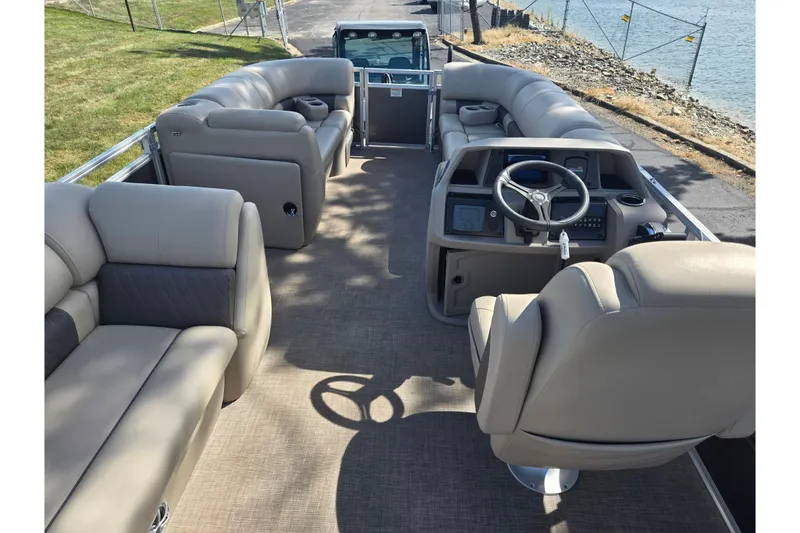 Slide: The Image of 2024 Sun Tracker Party Barge 20 DLX interior with plush seating and steering console. - 20