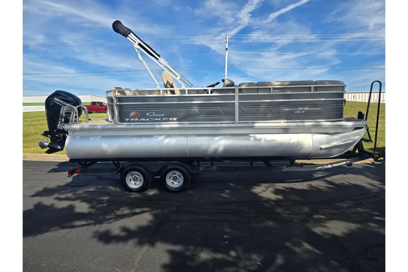 Slide: The Image of 2024 Sun Tracker Party Barge 20 DLX pontoon boat on trailer, side view. - 4