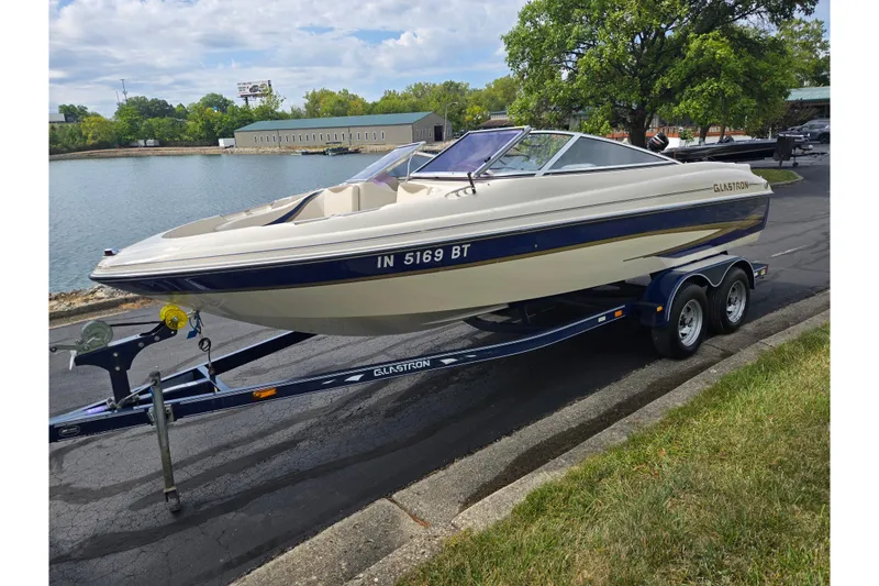 Slide: The Image of 2001 Glastron GX 205 boat on trailer by a lakeside road. - 8