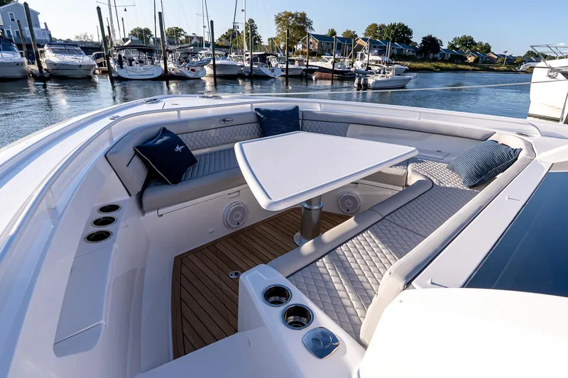 Slide: The Image of 2026 Valhalla V-55 Sport Yacht interior with elegant seating and table, docked at marina. - 43