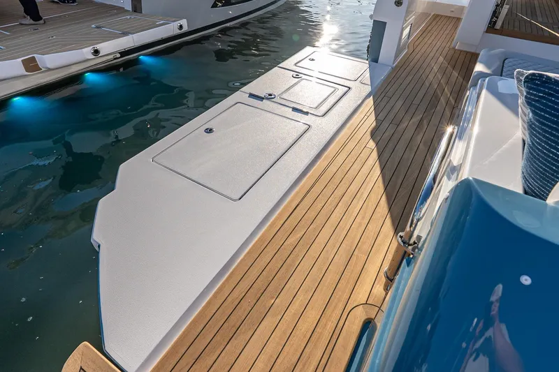 Slide: The Image of 2026 Valhalla V-55 Sport Yacht deck with sleek wood finish and water reflections. - 12