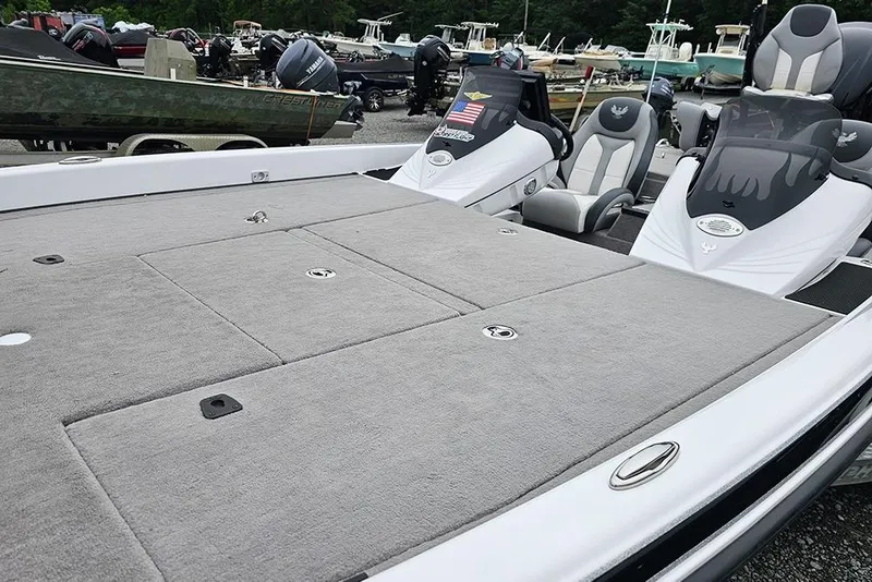 Slide: The Image of 2018 Phoenix 921 ProXP boat with spacious deck and seating, parked among other boats. - 13