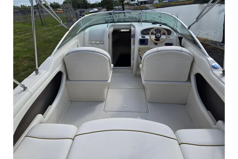 Slide: The Image of 2002 Sea Ray 225 Weekender boat interior with white seating and steering wheel. - 10