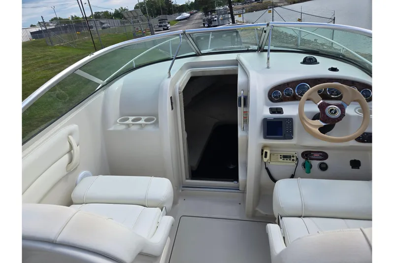 Slide: The Image of 2002 Sea Ray 225 Weekender boat interior with steering wheel and seating. - 11