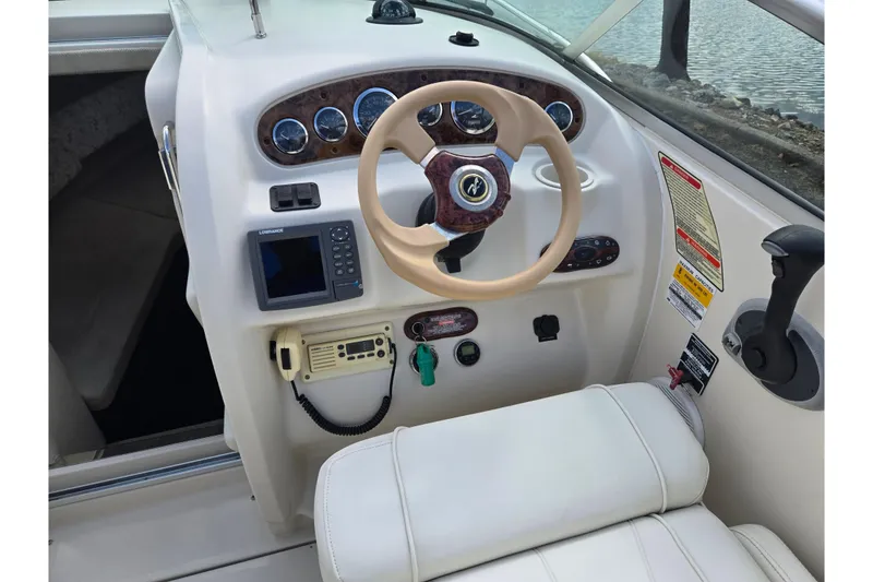 Slide: The Image of 2002 Sea Ray 225 Weekender boat dashboard with steering wheel and control panel. - 12