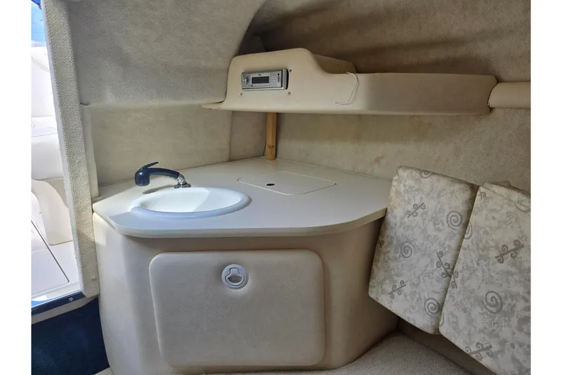 Slide: The Image of 2002 Sea Ray 225 Weekender cabin interior with sink and storage. - 17
