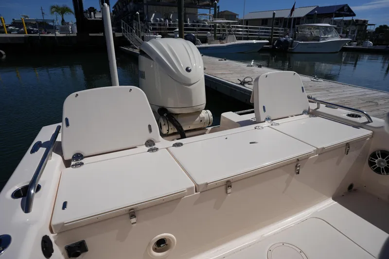 Slide: The Image of 2024 Grady-White 251 Coastal Explorer boat interior with seating and outboard motor at dock. - 21