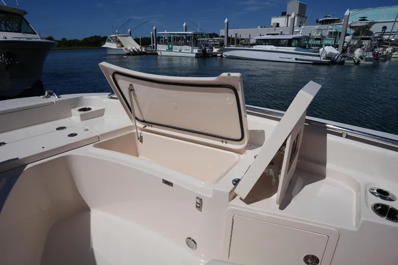 Slide: The Image of 2024 Grady-White 251 Coastal Explorer boat with open storage compartments at marina. - 38