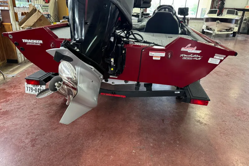 Slide: The Image of 2021 Bass Tracker Pro Team 195 boat, rear view with motor, in showroom setting. - 8