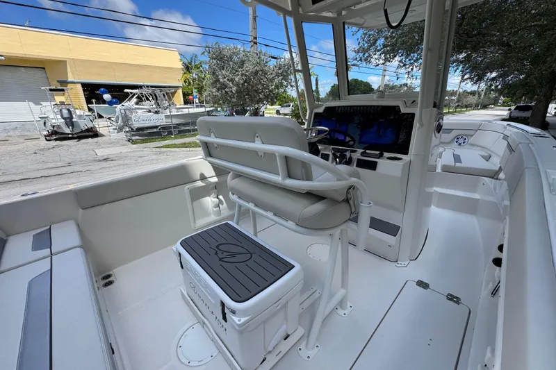 Slide: The Image of 2026 Sailfish 252 boat interior with helm, seating, and modern controls under a clear blue sky. - 11