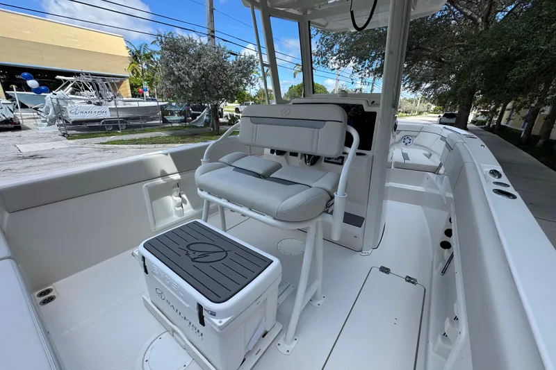 Slide: The Image of 2026 Sailfish 252 boat interior with seating and console, parked outdoors. - 12