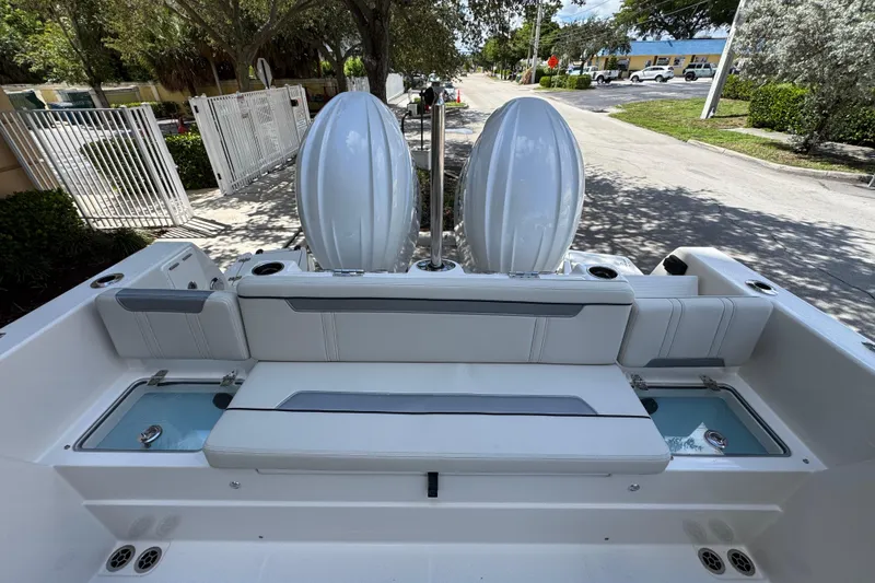Slide: The Image of 2026 Sailfish 252 boat interior with dual engines and seating, parked near a street. - 16