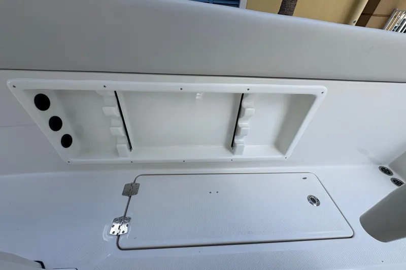 Slide: The Image of 2026 Sailfish 252 boat interior storage compartment with rod holders and hatch. - 21